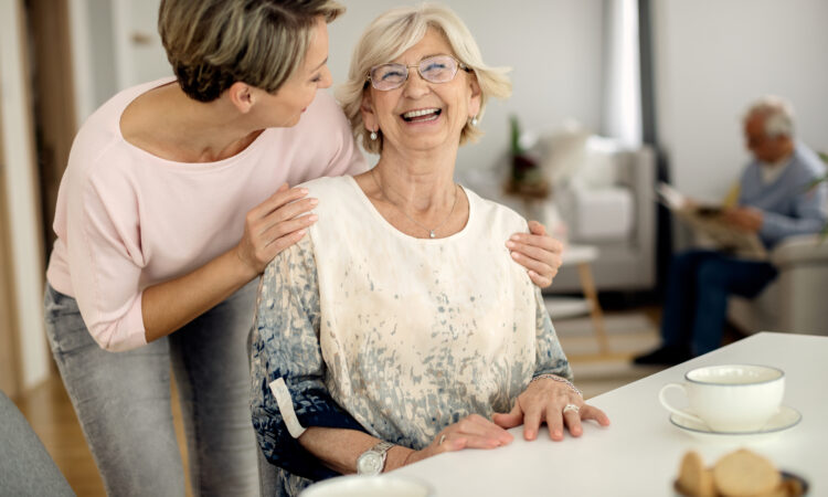 Cheerful senior woman having fun with her adult daughter at home